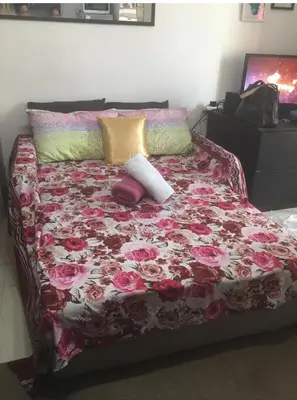 a bed with pillows on top of it at Cozy Starpad14R Stamford McKinley Hill in Manila