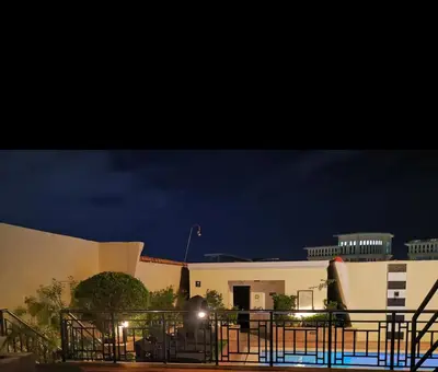 a building with a fence in front of it at night at Cozy Starpad14R Stamford McKinley Hill in Manila
