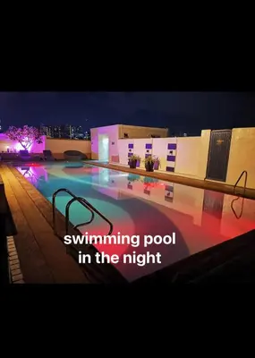 a swimming pool in the night with the words swimming pool in the night at Cozy Starpad14R Stamford McKinley Hill in Manila