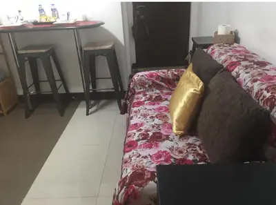 a living room with a couch and a table at Cozy Starpad14R Stamford McKinley Hill in Manila