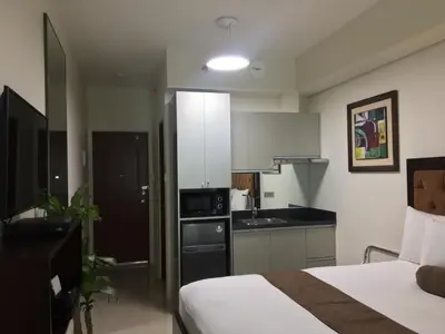 a hotel room with a bed and a kitchen at Studio unit at The Beacon Makati near Greenbelt in Manila