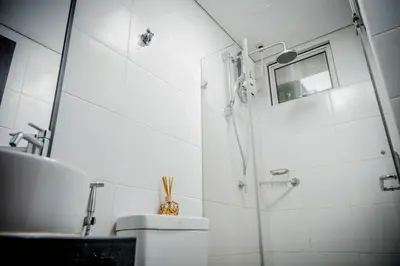 a bathroom with a shower and a toilet and a sink at Sunny Spot in Manila
