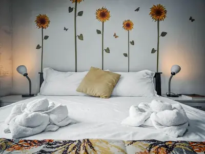 a bed with towels on it with flowers on the wall at Sunny Spot in Manila