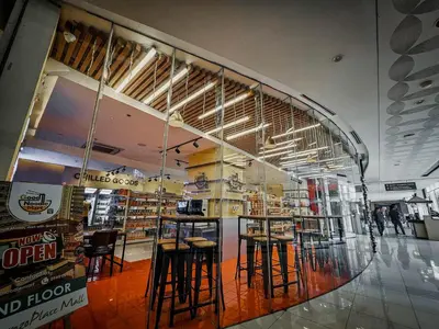 a store with stools in a large glass window at Sunny Spot in Manila