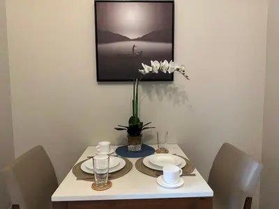 a table with plates and a vase of flowers on it at Executive Suite in Bonifacio Global City in Manila