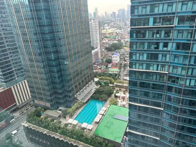 an aerial view of a pool between two tall buildings at Executive Suite in Bonifacio Global City in Manila