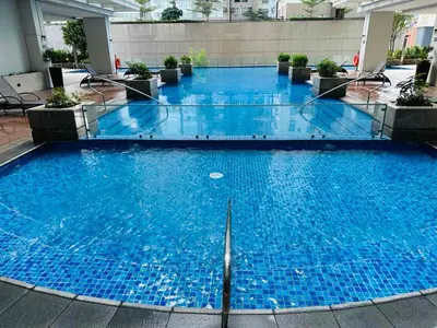 a large pool with blue water in a building at Executive Suite in Bonifacio Global City in Manila