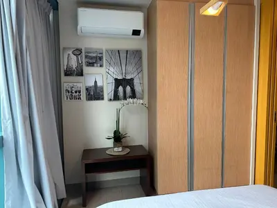 a bedroom with a bed and a table and a window at Executive Suite in Bonifacio Global City in Manila