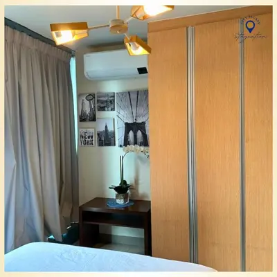 a bedroom with a bed and a cabinet and a table at Executive Suite in Bonifacio Global City in Manila