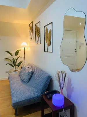 a room with a bed and a table with a mirror at cozy and minimalist room near airport in Manila