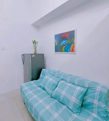a couch in a room with a painting on the wall at Sea Residences by Jan & Val Alano in Manila