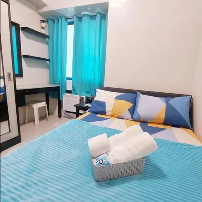 a bedroom with a bed with towels on it at Sea Residences by Jan & Val Alano in Manila