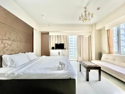 a bedroom with a large white bed and a couch at Cozy Spacious Condo Hotel near NAIA Manila Airport Pasay in Manila