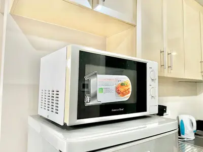 a microwave oven sitting on top of a counter at Cozy Spacious Condo Hotel near NAIA Manila Airport Pasay in Manila