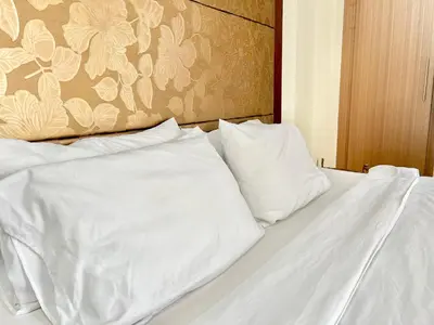 a bed with white sheets and pillows on it at Cozy Spacious Condo Hotel near NAIA Manila Airport Pasay in Manila