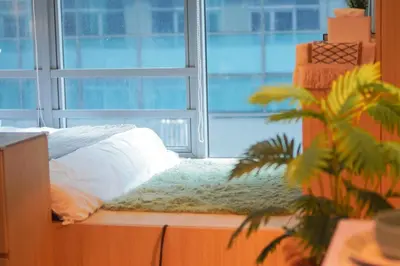 a bed in a room with a large window at 400mpbs, Free pool access! Eastwood LeGrand 3 - Mowai Suites in Manila