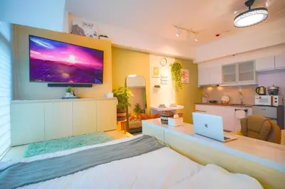 a bedroom with a large television on the wall at 400mpbs, Free pool access! Eastwood LeGrand 3 - Mowai Suites in Manila