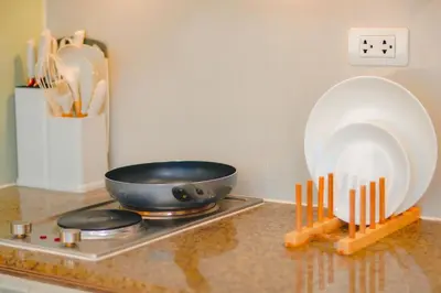 a counter top with a frying pan and plates on it at 400mpbs, Free pool access! Eastwood LeGrand 3 - Mowai Suites in Manila