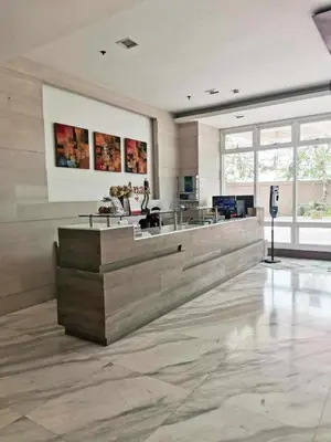 a lobby with a reception desk in a building at Studio Getaway in Alabang at Anuva Residences in Manila