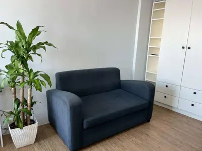a blue chair in a room with a plant at Studio Getaway in Alabang at Anuva Residences in Manila