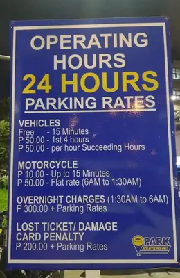 a sign for a hours parking rates at Cozy Private Condo at Shore 3 near MOA in Manila