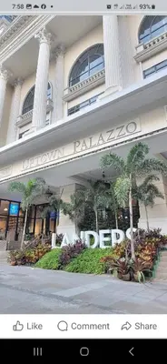 a sign on the front of a building with palm trees at Cozy Pad BGC in Manila