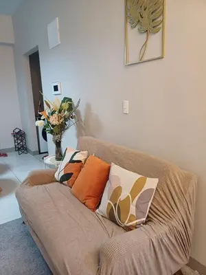 a couch with pillows on it in a living room at Cozy Pad BGC in Manila