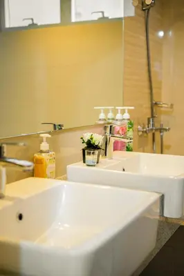 a bathroom with two white sinks and a mirror at Luxurious 2 Bedroom in Uptown BGC Taguig in Manila