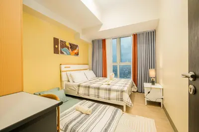 a hotel room with two beds and a window at Luxurious 2 Bedroom in Uptown BGC Taguig in Manila