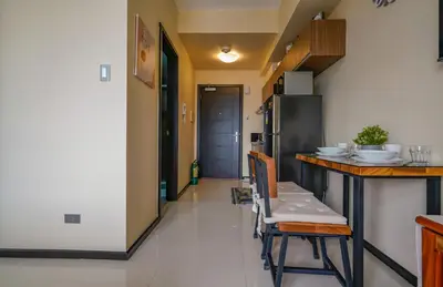 a kitchen with a counter and a table and chairs at The Radiance Manila Bay Studio in Manila