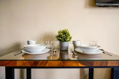 a table with two white dishes and a plant on it at The Radiance Manila Bay Studio in Manila