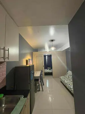 a kitchen and living room with a table and a bed at Sea Residences Yeshua infront of MOA Pasay in Manila