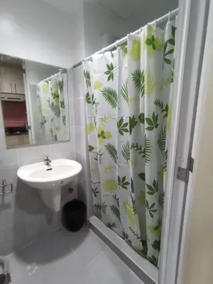 a bathroom with a shower curtain and a sink at Sea Residences Yeshua infront of MOA Pasay in Manila