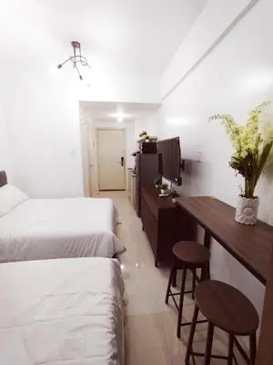 a bedroom with two beds and a desk with two stools at Hotel Luxury Twin Bed Room with Balcony Las Pinas-South Residence in Manila