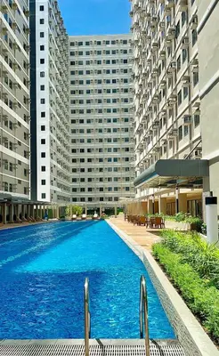 a large swimming pool in front of two tall buildings at Samuel staycation in Smdc Green2 one studio unit in Dasmariñas