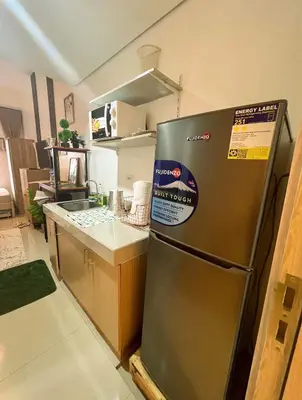 a kitchen with a stainless steel refrigerator in a room at Samuel staycation in Smdc Green2 one studio unit in Dasmariñas