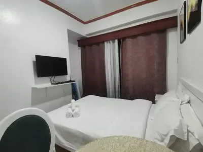 a hotel room with a bed and a television at romantic makati in Manila