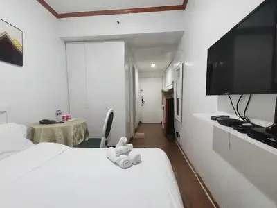 a hotel room with a bed and a flat screen tv at romantic makati in Manila