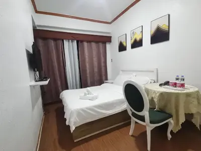 a bedroom with a bed and a table and a chair at romantic makati in Manila