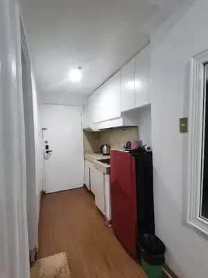 a small kitchen with a red refrigerator and white cabinets at romantic makati in Manila