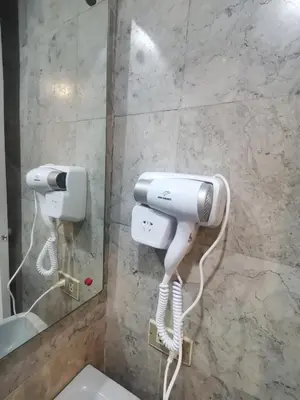 a bathroom with a white hair dryer and a mirror at romantic makati in Manila