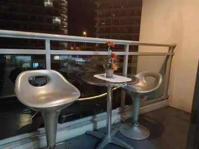 a balcony with a table and two chairs and a window at Azure Urban Residence A11 Near Airport and SM Bicutan+ Free wifi in Manila