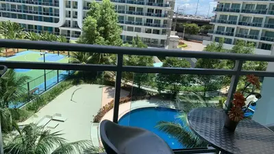 a balcony with a table and a view of a pool at Azure Urban Residence A11 Near Airport and SM Bicutan+ Free wifi in Manila
