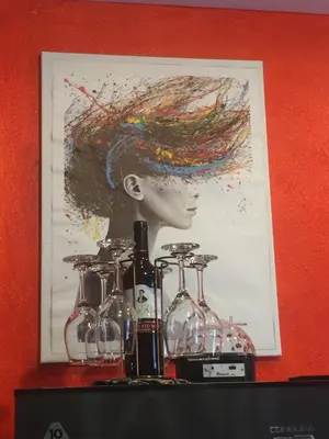 a picture of a woman with a hat and wine glasses at La Coccinella in Manila