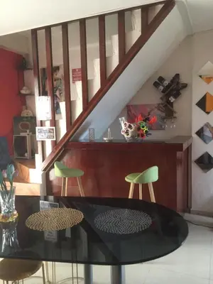 a dining room with a glass table and green chairs at La Coccinella in Manila