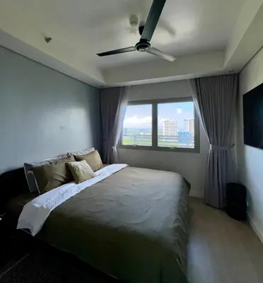 a bedroom with a bed with a ceiling fan at Modern 1BR Executive Suite l Best City View of BGC l The Residences BCCT in Manila