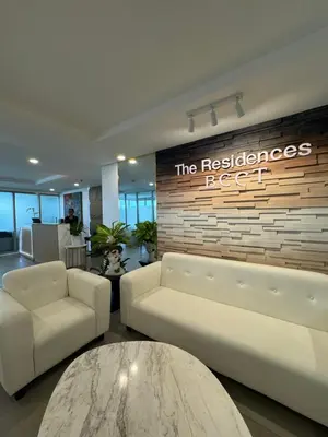 a lobby with two white couches and a sign on a brick wall at Modern 1BR Executive Suite l Best City View of BGC l The Residences BCCT in Manila