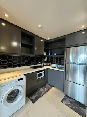 a kitchen with a washing machine and a dishwasher at Modern 1BR Executive Suite l Best City View of BGC l The Residences BCCT in Manila