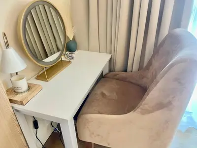 a chair sitting next to a desk with a mirror at Cozy Place @ Venice Luxury Residences in Manila