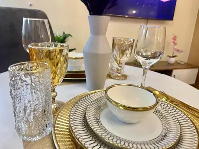 a table with plates and glasses on a table at Cozy Place @ Venice Luxury Residences in Manila